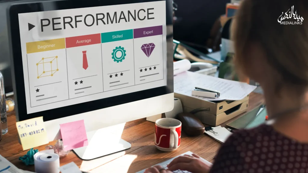 Person analyzing performance metrics on desktop screen showing beginner to expert levels in a digital marketing workspace.