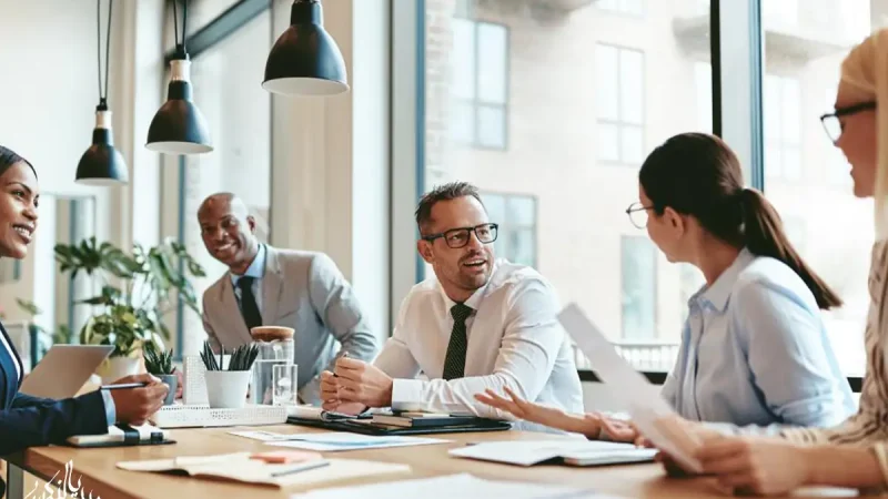 Team of professionals discussing documents and collaborating during a business meeting in a modern office.