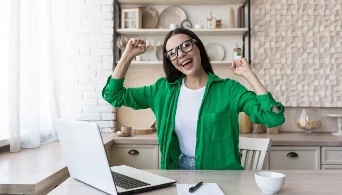 Exciting a female for achieving something on laptop.