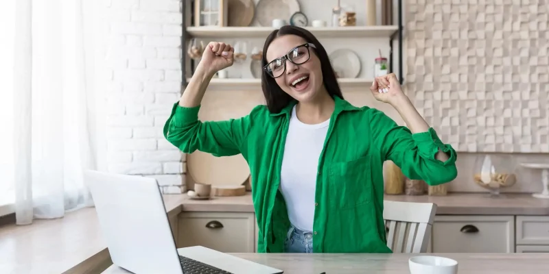 Exciting a female for achieving something on laptop.