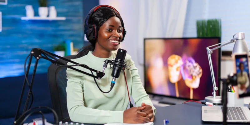 Social media star talking at camera and recording a new episode of show. Speaking during livestreaming, blogger discussing in podcast wearing headphones.