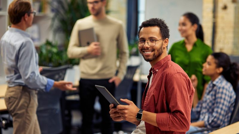 young-cheerful-mixed-race-man-holding-digital-tabl-2021-12-09-07-13-15-utc-scaled
